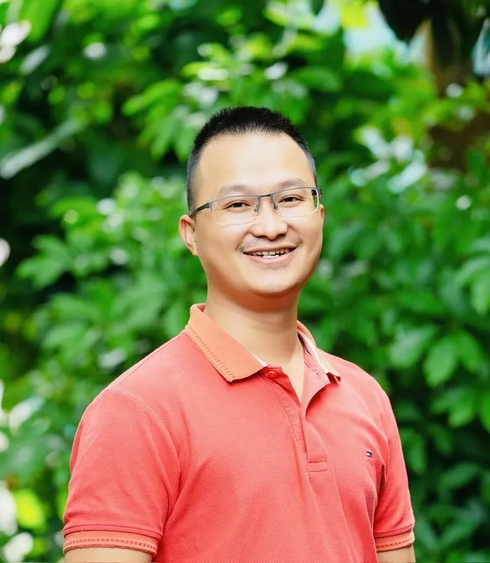 Mark Ton, người sáng lập Petami, áo thun cam, nền lá xanh