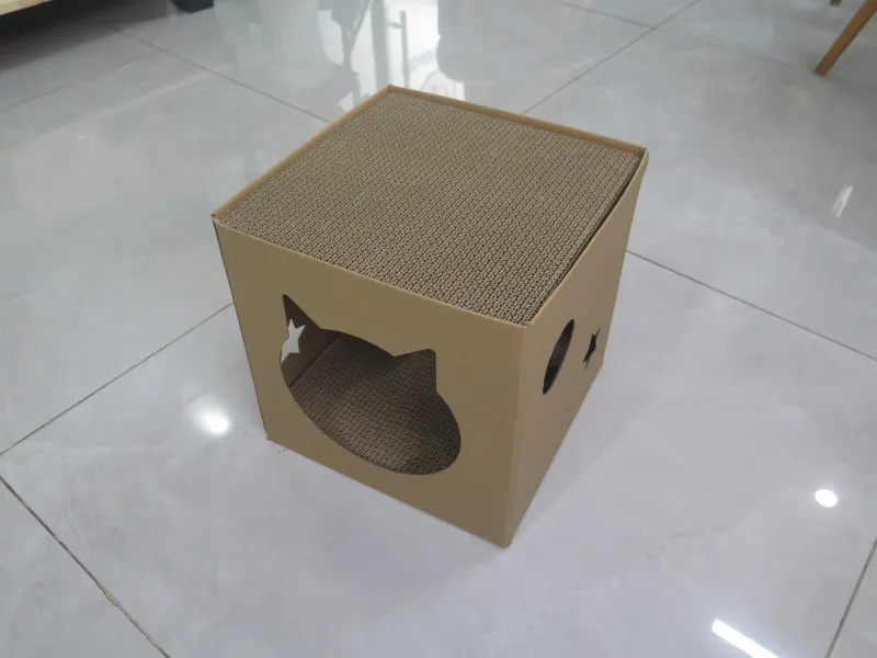 Nhà mèo bằng carton, nóc là mặt cào móng, cửa khoét hình đầu mèo